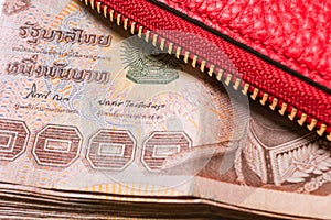 Red leather wallet with thai banknote money, close up