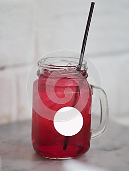 Red lemon soda water flavoured drink, Cool Drinks Beverages with ice in clear glass on white table