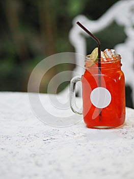 Red lemon soda water flavoured drink, Cool Drinks Beverages with ice in clear glass on white table