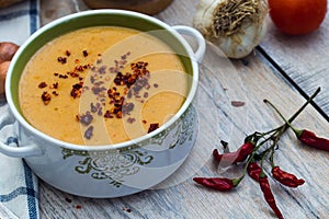 Red lentil soup with vegetables on the wooden background