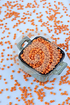 Red lentils in a bowl isolated on white background