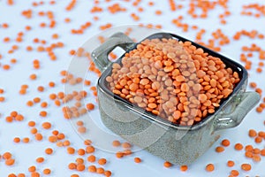 Red lentils in a bowl isolated on white background, close-up