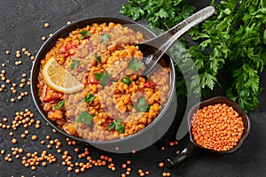 Red lentils dal in black bowl. Lentils tomato dhal is indian cuisine dish. Indian food. Asian vegetarian meal