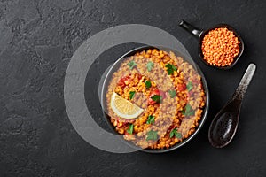 Red lentils dal in black bowl. Lentils tomato dhal is indian cuisine dish. Indian food. Asian vegetarian meal