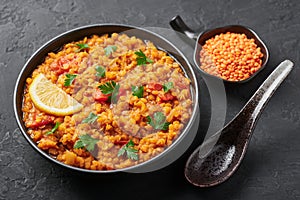 Red lentils dal in black bowl. Lentils tomato dhal is indian cuisine dish. Indian food. Asian vegetarian meal