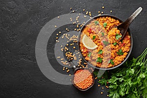 Red lentils dal in black bowl. Lentils tomato dhal is indian cuisine dish. Indian food. Asian vegetarian meal