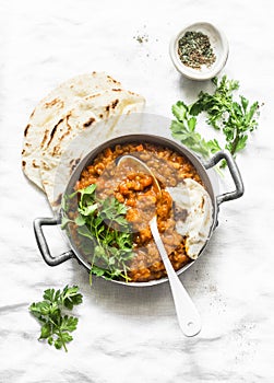 Red lentils dhal and paratha flatbread - healthy vegetarian dinner in Indian style on light background