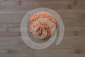 Red lentils Forming a Circle on Wooden Cutting Board