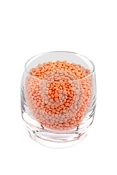 Red lentils in glass, white background