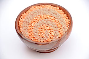 The red lentils  pulse in the wooden bowl isolated in white  background