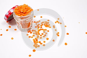 Red lentils in a glass jar, on a white background