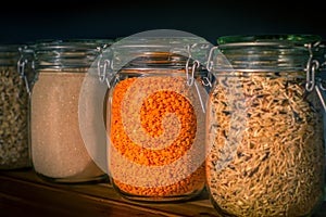 Red Lentils and Wild Rice in Jars Amongst Dry Goods in a Kitchen Pantry