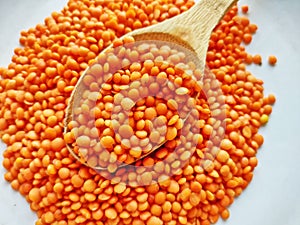 Red lentils on a wooden spoon