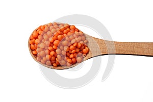 red lentils in wooden spoon isolated on white background. Top view