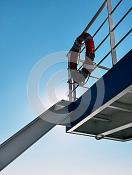 A Red Life Preserver on a Ferry Against a Blue Sky