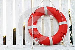 The red lifebuoy is located on the white veranda