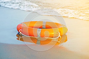 Red lifebuoy pool ring float. Life ring on the sea sand