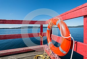 Red lifebuoy on a red ocean pier