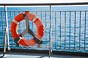 Red lifebuoy with rope on the ferry