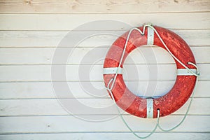 Red lifebuoy on a white wooden wall. Background, copyspace