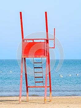 Red lifeguard chair on an empty beach