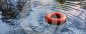 Red lifesaver floating on tranquil water