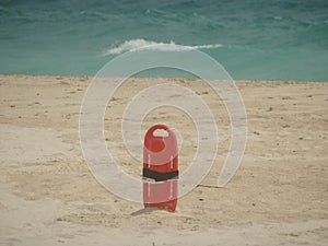 Red Lifesaver lifeguard in sand at beach