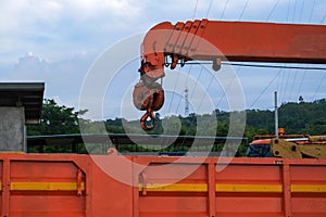 Red lifting crane hook with tower on mobile crane in construction site