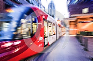 Red light rail train in close up, image in zoom-blur effect for background.