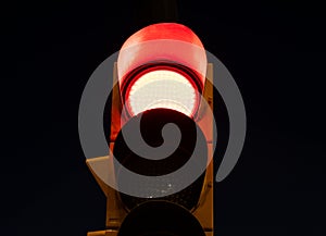 Red light on a traffic light at the street at night