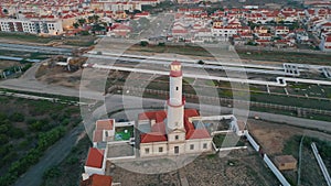 Red lighthouse drone view at seaside town. Urban infrastructure in port city.