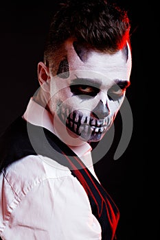 Red lights on man with creative make-up for the Halloween party.