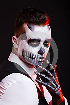 Red lights on man with creative make-up for the Halloween party.