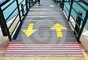 Red line at the start-end point and two way yellow traffic arrows sign on wooden bridge