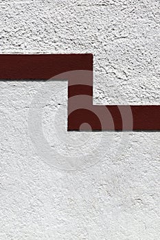 Red line on a white facade as a divider between grades of coarseness