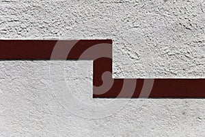 Red line on a white facade as a divider between grades of coarseness