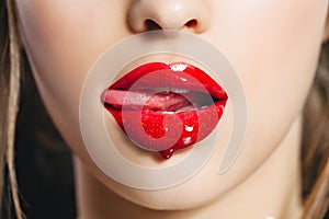 Red lip gloss. Closeup mouth with tongue. Saturated color