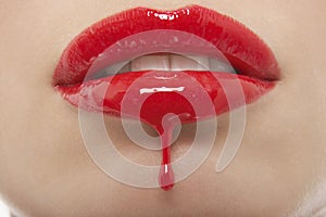 Red Lipgloss Dripping From Woman's Lips photo