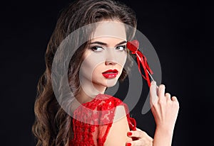 Red lips. Beautiful brunette girl portrait holding heart gift for Valentines Day. Sensual woman with long hair style isolated on