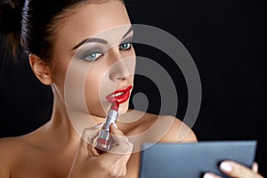Red lips. Beutifull Woman Doing Makeup Applying lipstick