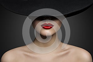 Red Lips Make up Closeup. Mysterious Fashion Woman Face Hidden by Black brimmed Hat. Elegant Retro Lady Fine Art Portrait photo