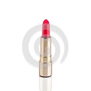 Red lipstick in golden tube on white background with mirror reflection on glass surface isolated close up, open pink lipstick