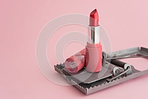 Red lipstick in rat trap on pink background copy space. Online internet romance scam or swindler in website application dating photo