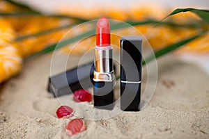 Red lipstick on sand