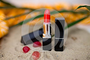 Red lipstick on sand