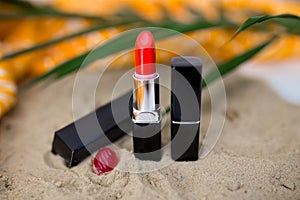 Red lipstick on sand