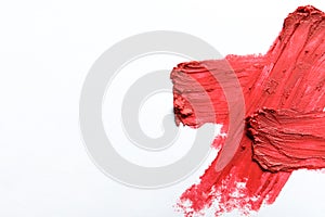 Red lipstick smear on white background, top view