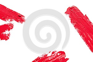 Red lipstick smears on white background, top view.