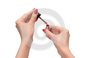 Red liquid lipstick in woman hands with red nails isolated on a white background