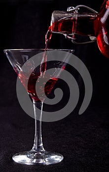 Red liquid poured into a cocktail glass